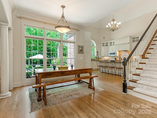 2516 Selwyn Ave, Charlotte, NC 28209 - dining room with stairway, decorative columns, light wood-style flooring, a chandelier, and baseboards
