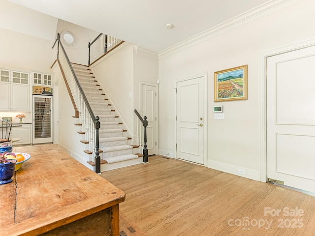 2516 Selwyn Ave, Charlotte, NC 28209 - foyer entrance with stairs, light wood-style floors, baseboards, and crown molding