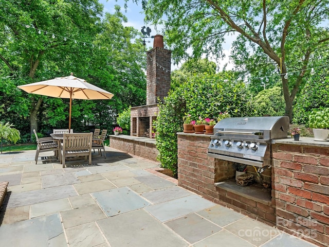 2516 Selwyn Ave, Charlotte, NC 28209 - view of patio / terrace with an outdoor brick fireplace and outdoor dining space