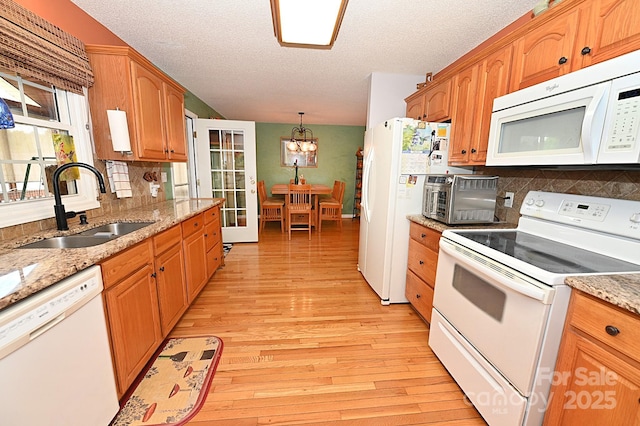4646 River Run Cir, Hickory, NC 28602 - kitchen with white appliances, a sink, a chandelier, light wood-style floors, and a textured ceiling