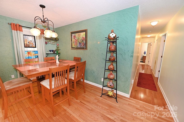 4646 River Run Cir, Hickory, NC 28602 - dining room featuring light wood-style flooring, a textured ceiling, a chandelier, and baseboards