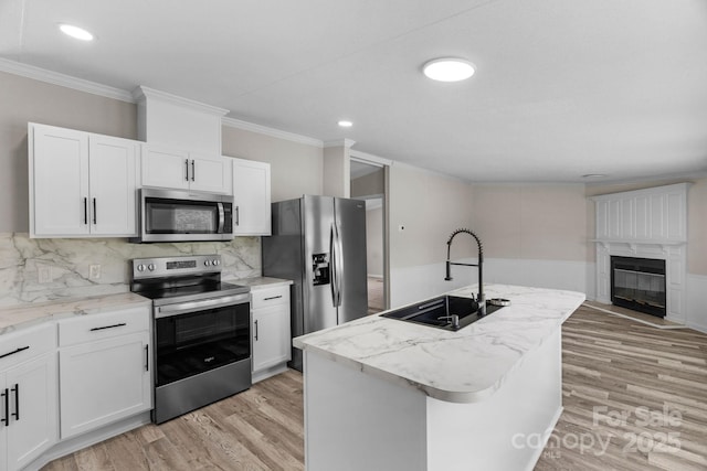 5606 S Rocky River Rd, Monroe, NC 28112 - kitchen with stainless steel appliances, a sink, ornamental molding, light wood-type flooring, and white cabinets