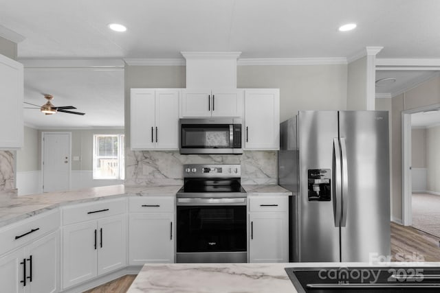 5606 S Rocky River Rd, Monroe, NC 28112 - kitchen with stainless steel appliances, ceiling fan, white cabinets, light wood-style flooring, and ornamental molding