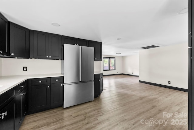 103 Fleetwood Rd, York, SC 29745 - kitchen featuring freestanding refrigerator, dark cabinetry, light countertops, light wood-type flooring, and open floor plan