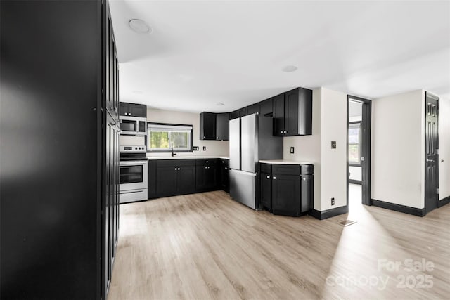 103 Fleetwood Rd, York, SC 29745 - kitchen featuring appliances with stainless steel finishes, light wood-style flooring, light countertops, and dark cabinets