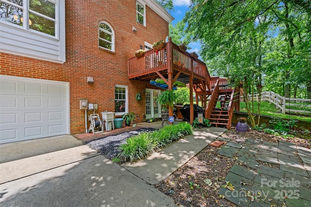 8217 Lansford Rd, Charlotte, NC 28277 - rear view of property featuring a wooden deck, brick siding, stairs, a garage, and driveway