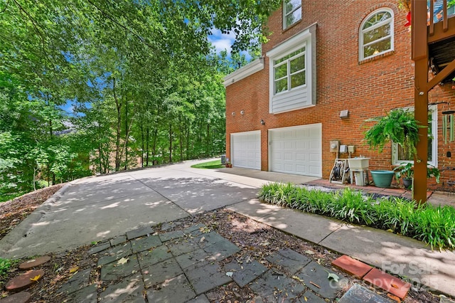 8217 Lansford Rd, Charlotte, NC 28277 - view of side of home featuring brick siding, an attached garage, and driveway
