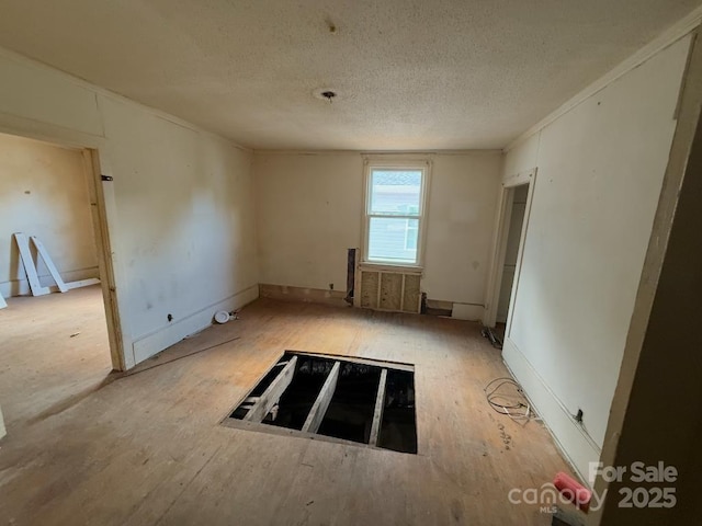 324 S Spruce St, Rock Hill, SC 29730 - spare room featuring a textured ceiling, wood finished floors, and radiator heating unit