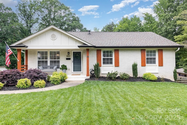 1621 Brookdale Ave, Charlotte, NC 28210 - ranch-style home featuring a shingled roof, brick siding, board and batten siding, a porch, and a front lawn