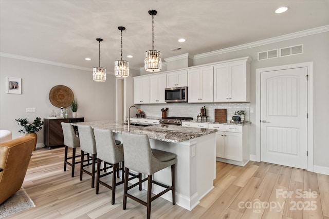 602 Compass Dr, Denver, NC 28037 - kitchen with stainless steel appliances, a kitchen breakfast bar, tasteful backsplash, a chandelier, and white cabinets
