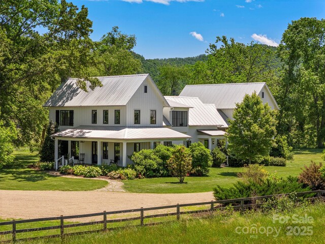 146 Lower Brush Creek Rd, Fletcher, NC 28732 - modern inspired farmhouse featuring a porch, metal roof, and a view of trees