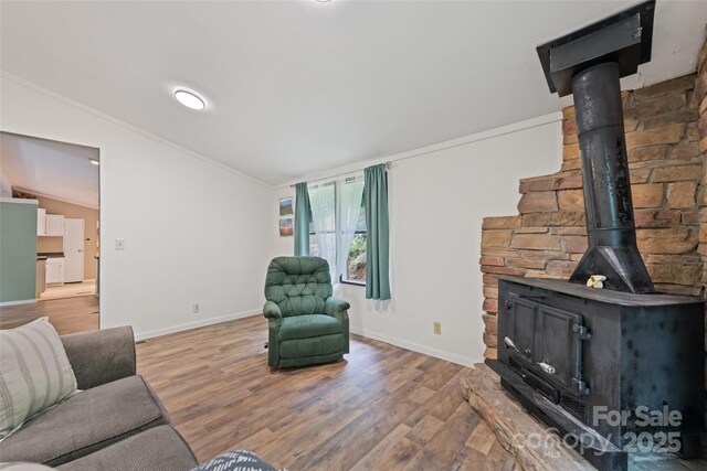 100 Bettys Dr, Waynesville, NC 28786 - living area featuring a wood stove, lofted ceiling, light wood finished floors, baseboards, and crown molding