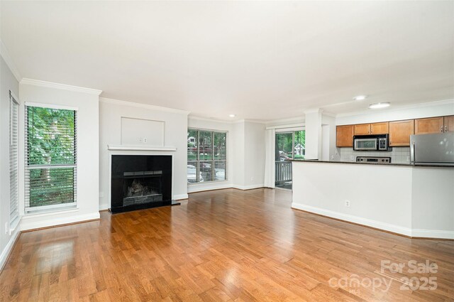 2512 Cranbrook Ln Unit 9, Charlotte, NC 28207 - unfurnished living room featuring light wood-style flooring, baseboards, ornamental molding, a fireplace, and recessed lighting