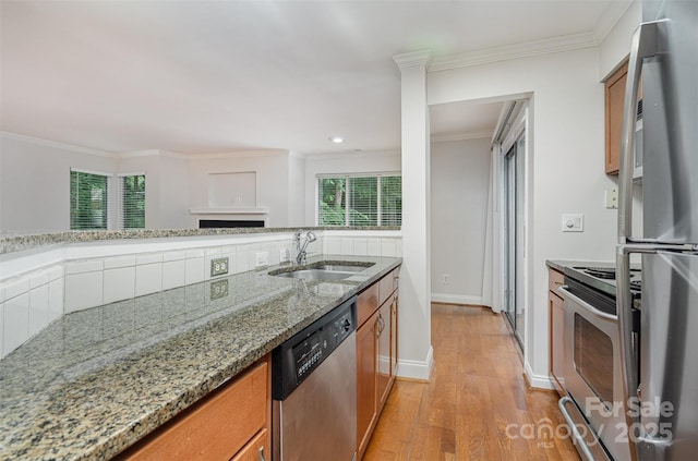 2512 Cranbrook Ln Unit 9, Charlotte, NC 28207 - kitchen featuring stainless steel appliances, a sink, brown cabinets, light wood-type flooring, and crown molding