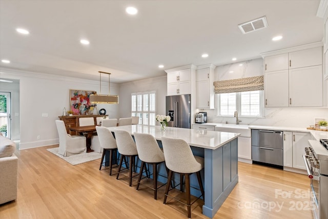 5917 Bridger Ct, Charlotte, NC 28211 - kitchen featuring high quality appliances, a sink, plenty of natural light, white cabinets, and crown molding