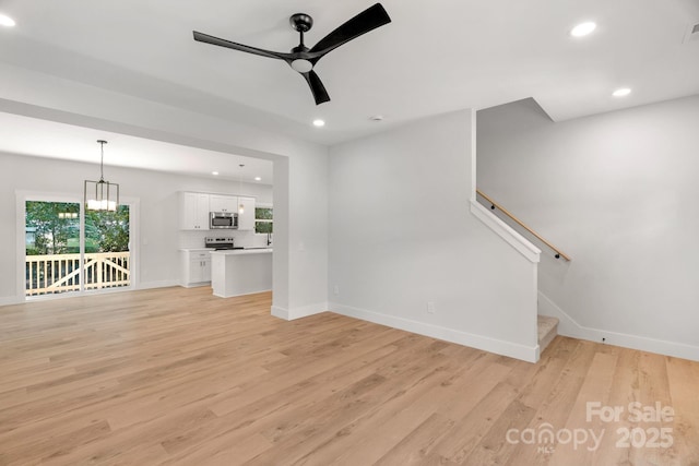 7874 Lucky Creek Ln, Denver, NC 28037 - unfurnished living room with baseboards, recessed lighting, ceiling fan, light wood-type flooring, and stairs