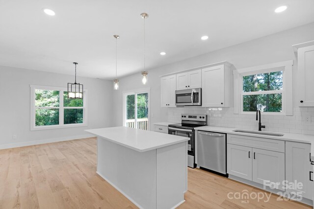 7874 Lucky Creek Ln, Denver, NC 28037 - kitchen featuring stainless steel appliances, a sink, light countertops, tasteful backsplash, and light wood finished floors