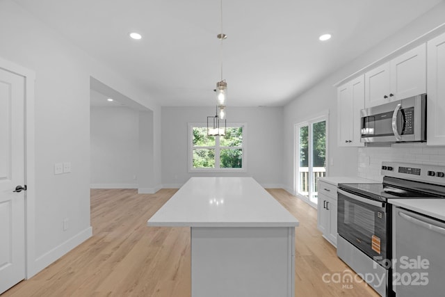 7874 Lucky Creek Ln, Denver, NC 28037 - kitchen featuring stainless steel appliances, a center island, light countertops, white cabinets, and light wood-style floors