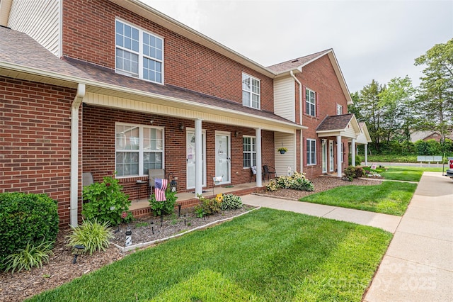 102 Brandywine Dr NE Unit O-3, Conover, NC 28613 - view of front of house with a porch, a front lawn, brick siding, and a shingled roof