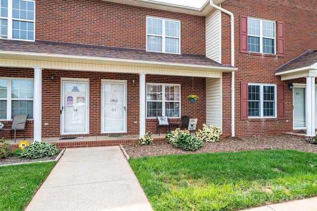 102 Brandywine Dr NE Unit O-3, Conover, NC 28613 - doorway to property featuring covered porch, roof with shingles, brick siding, and a lawn