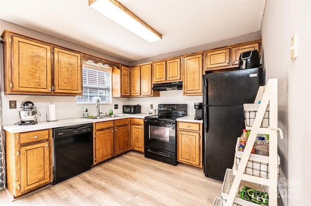 102 Brandywine Dr NE Unit O-3, Conover, NC 28613 - kitchen with black appliances, under cabinet range hood, light wood-type flooring, a sink, and light countertops