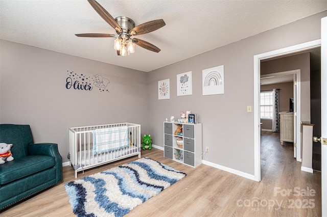 102 Brandywine Dr NE Unit O-3, Conover, NC 28613 - bedroom featuring wood finished floors, baseboards, a crib, and a textured ceiling