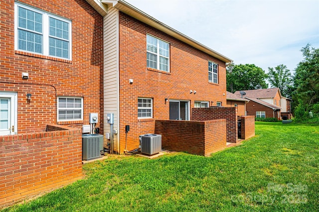102 Brandywine Dr NE Unit O-3, Conover, NC 28613 - back of house with central air condition unit, a yard, and brick siding