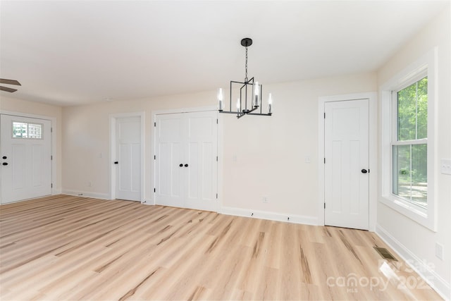 406 N Bostian St, China Grove, NC 28023 - unfurnished dining area featuring a chandelier, light wood-style floors, and healthy amount of natural light