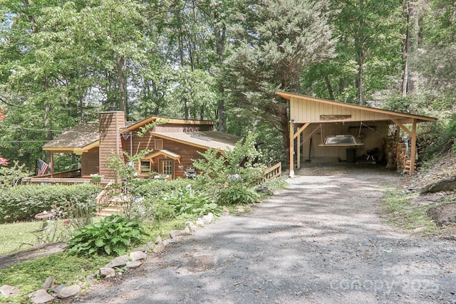 46 Thrush Dr, Maggie Valley, NC 28751 - view of side of property featuring gravel driveway, a chimney, and a carport