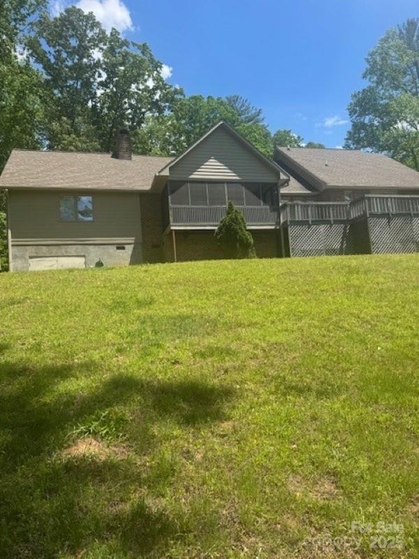 240 Goshen Ter, Wilkesboro, NC 28697 - back of house featuring a sunroom, a chimney, and a lawn