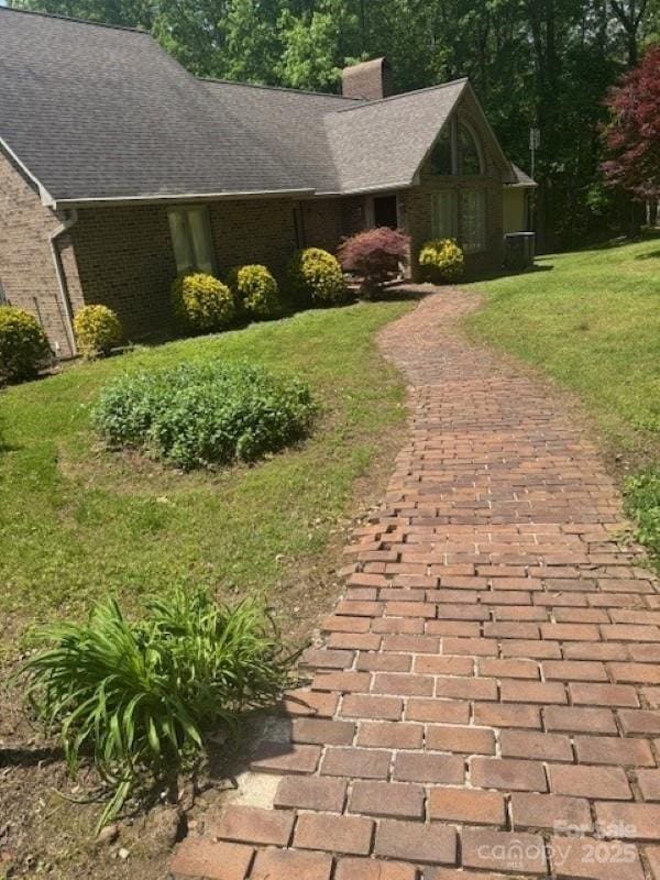 240 Goshen Ter, Wilkesboro, NC 28697 - view of front of house with a chimney, a front lawn, a shingled roof, and brick siding