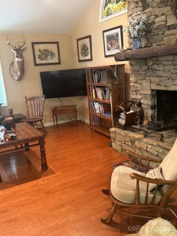 240 Goshen Ter, Wilkesboro, NC 28697 - living room featuring vaulted ceiling, wood finished floors, and a stone fireplace