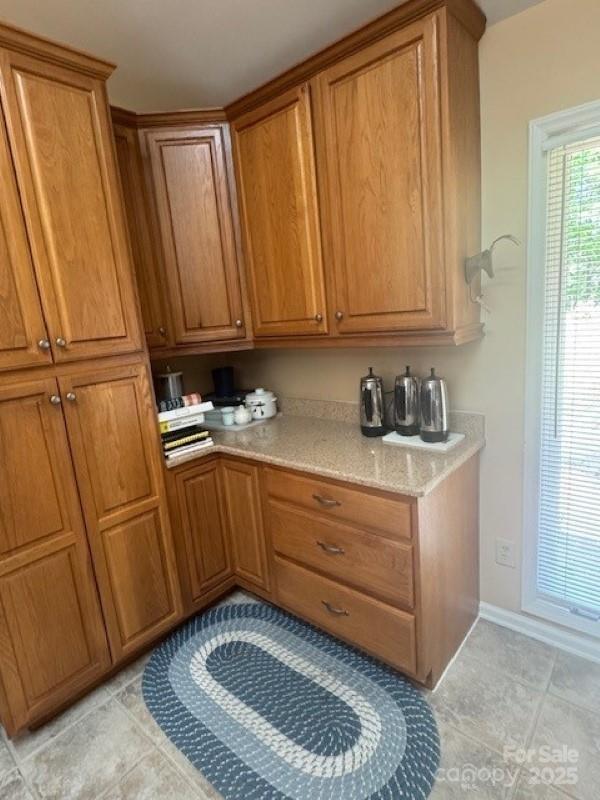 240 Goshen Ter, Wilkesboro, NC 28697 - kitchen with brown cabinetry, light tile patterned floors, and baseboards