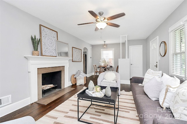 2421 Shamrock Dr, Charlotte, NC 28205 - living area with wood finished floors, a ceiling fan, a fireplace with flush hearth, arched walkways, and baseboards
