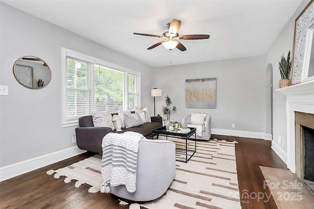 2421 Shamrock Dr, Charlotte, NC 28205 - living area with a ceiling fan, wood finished floors, arched walkways, and a fireplace with flush hearth