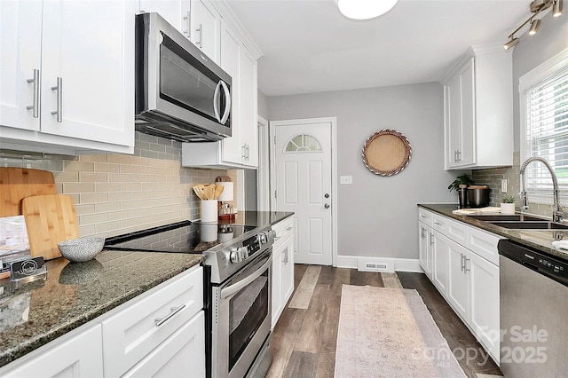 2421 Shamrock Dr, Charlotte, NC 28205 - kitchen with appliances with stainless steel finishes, a sink, dark wood finished floors, and white cabinets