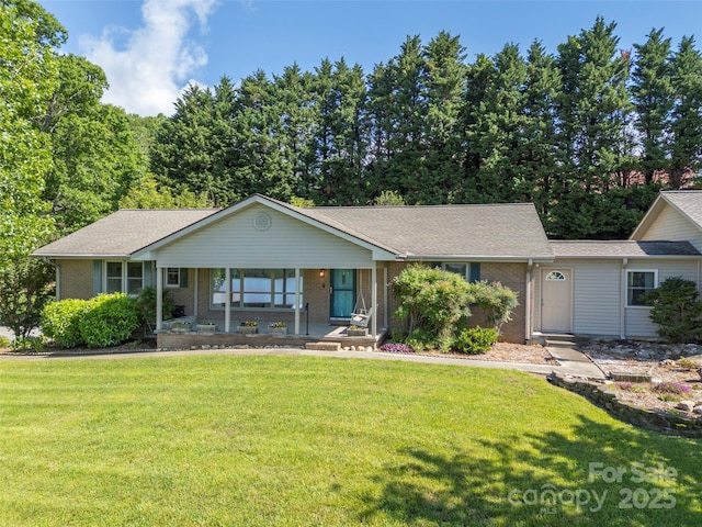 418 Mountain Page Rd, Saluda, NC 28773 - ranch-style home featuring brick siding, covered porch, a front yard, and roof with shingles