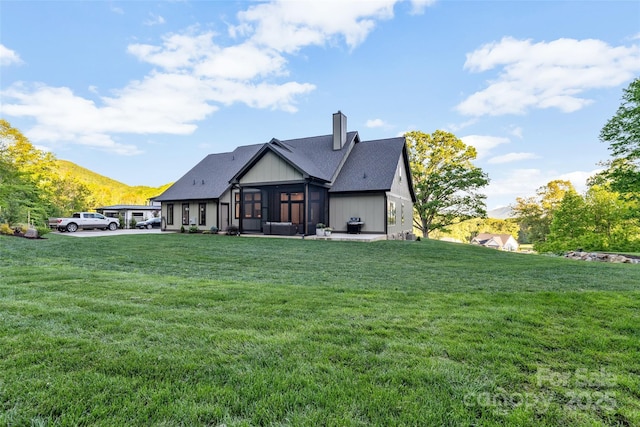 10 Slate Dr, Candler, NC 28715 - rear view of house featuring a sunroom, a lawn, a chimney, and a mountain view