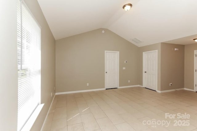 2599 April Showers Ln, Rock Hill, SC 29730 - spare room featuring vaulted ceiling, light tile patterned floors, and baseboards
