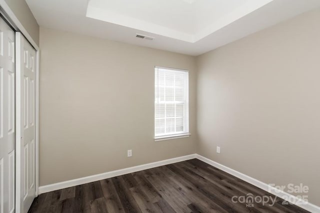 2599 April Showers Ln, Rock Hill, SC 29730 - unfurnished bedroom with dark wood finished floors, a closet, baseboards, and a raised ceiling