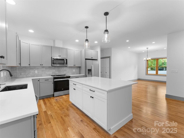 314 Gallimore Rd Unit 1, Brevard, NC 28712 - kitchen with stainless steel appliances, a sink, light countertops, tasteful backsplash, and light wood-type flooring