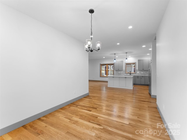 314 Gallimore Rd Unit 1, Brevard, NC 28712 - unfurnished living room featuring a chandelier, recessed lighting, light wood finished floors, baseboards, and a sink