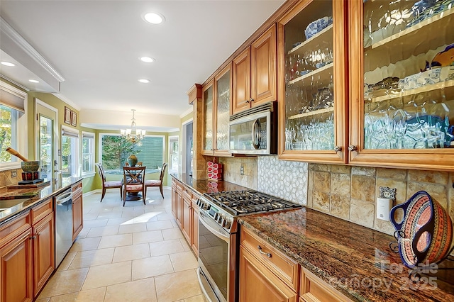 29049 Snapper Pt, Tega Cay, SC 29708 - kitchen with appliances with stainless steel finishes, a chandelier, backsplash, dark stone countertops, and recessed lighting