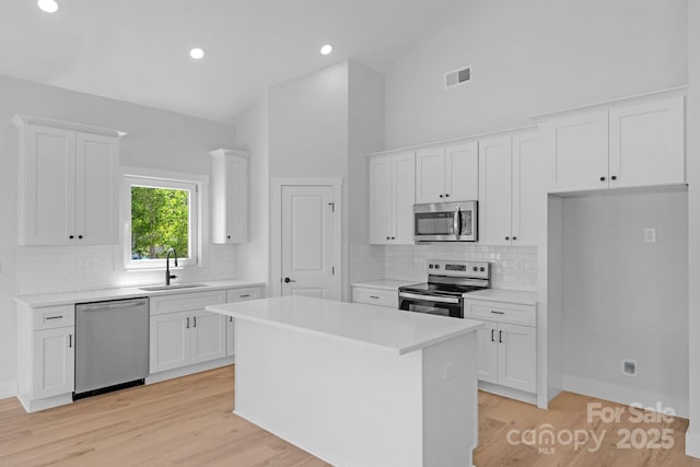 2104 County Line Rd, Kings Mountain, NC 28086 - kitchen featuring stainless steel appliances, a sink, white cabinets, high vaulted ceiling, and recessed lighting