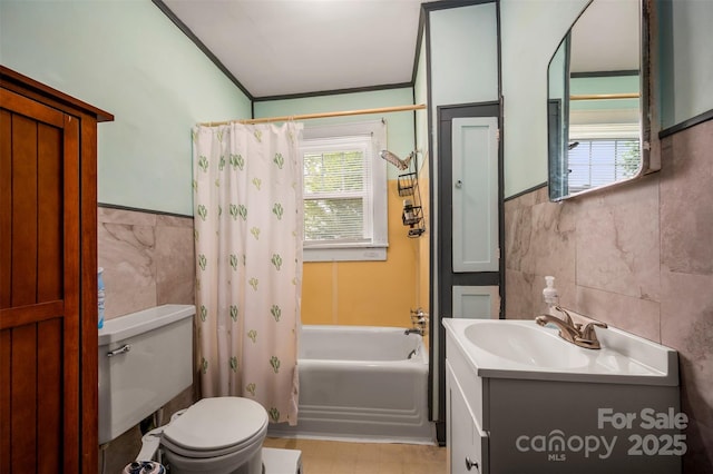 123 N Poston St, Shelby, NC 28150 - bathroom featuring tile walls, toilet, vanity, a wainscoted wall, and shower / bathtub combination with curtain