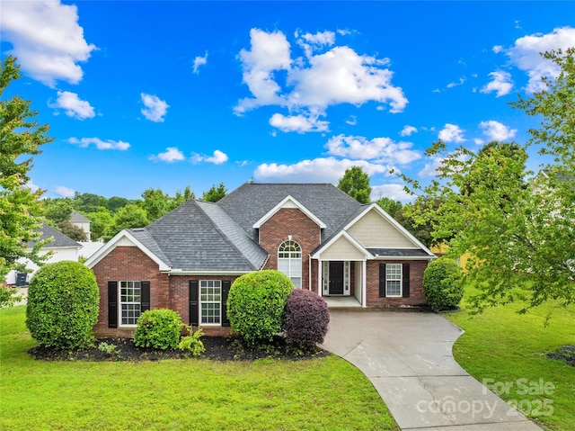 4809 Mossy Cup Ln, Monroe, NC 28110 - traditional-style home featuring brick siding, a front lawn, driveway, and roof with shingles