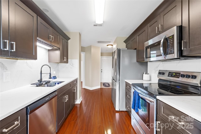 4809 Mossy Cup Ln, Monroe, NC 28110 - kitchen with appliances with stainless steel finishes, a sink, light countertops, and dark brown cabinetry