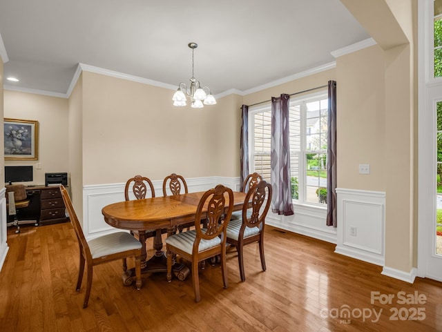 24 Yorktown Cir, Arden, NC 28704 - dining room featuring light wood finished floors, a chandelier, crown molding, a wainscoted wall, and a decorative wall