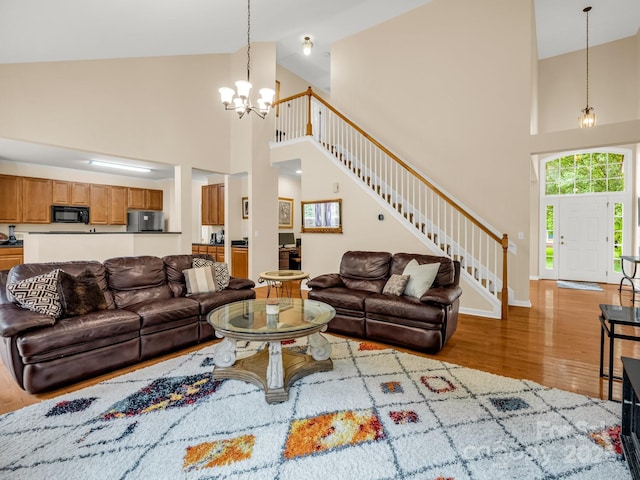 24 Yorktown Cir, Arden, NC 28704 - living area featuring wood finished floors, high vaulted ceiling, a chandelier, stairs, and baseboards