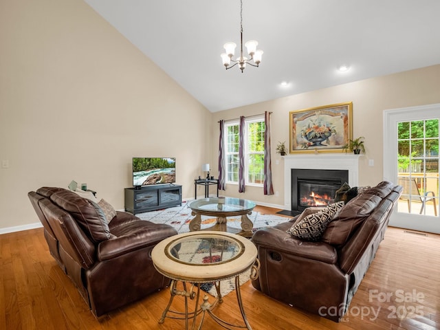 24 Yorktown Cir, Arden, NC 28704 - living area with a fireplace with flush hearth, wood finished floors, a chandelier, baseboards, and vaulted ceiling